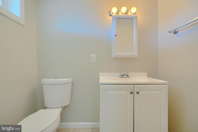 bathroom with vanity, toilet, and baseboards