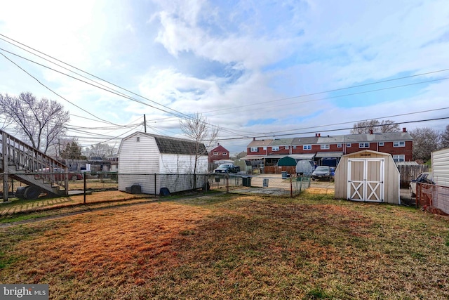 view of yard featuring a storage unit, an outdoor structure, and fence