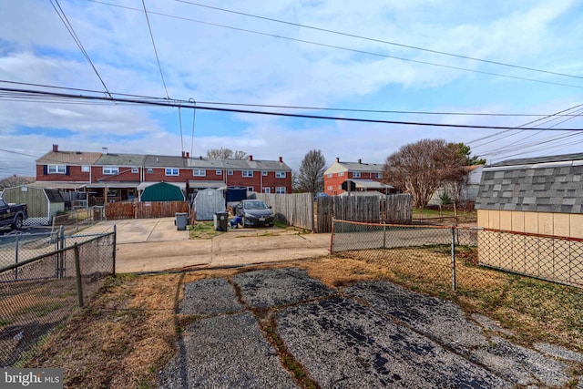 view of yard with an outbuilding, a storage unit, and fence