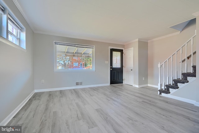 foyer entrance with crown molding, wood finished floors, and a healthy amount of sunlight