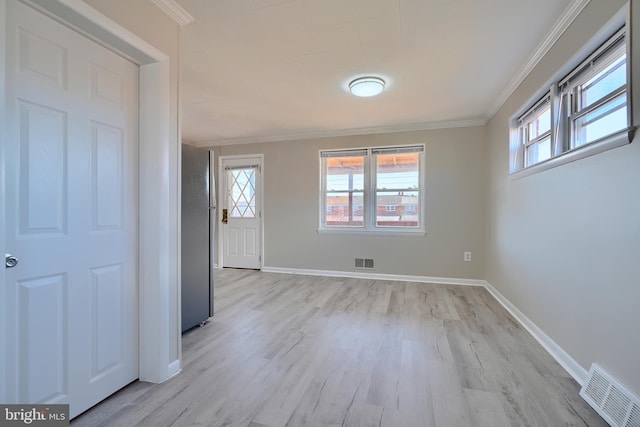 unfurnished room with visible vents, a wealth of natural light, and ornamental molding