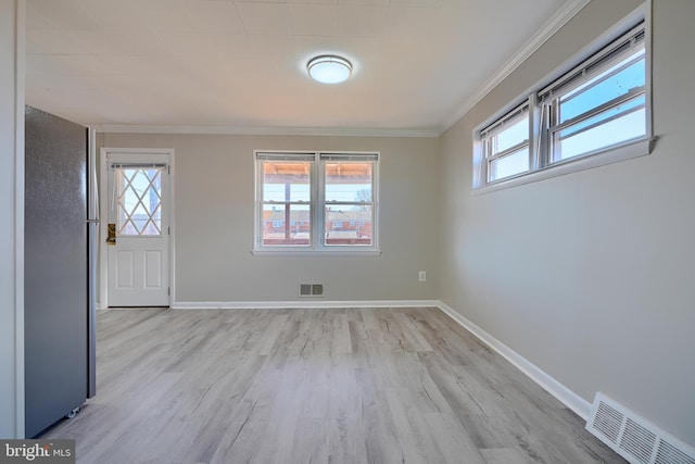 entryway featuring a wealth of natural light, visible vents, baseboards, and ornamental molding