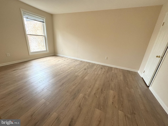 empty room featuring baseboards and wood finished floors