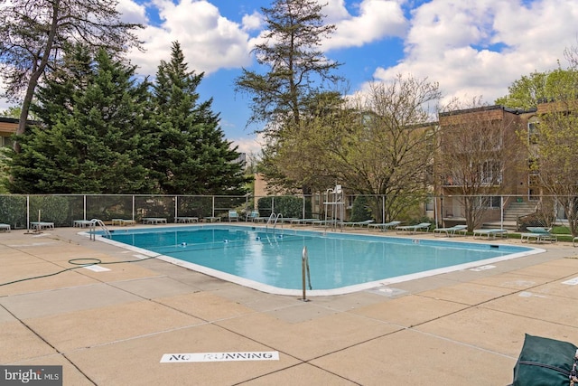 pool with a patio and fence