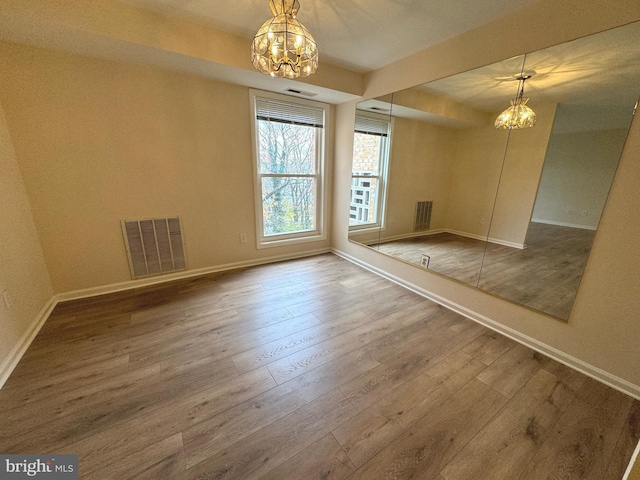 unfurnished bedroom featuring visible vents, baseboards, and wood finished floors