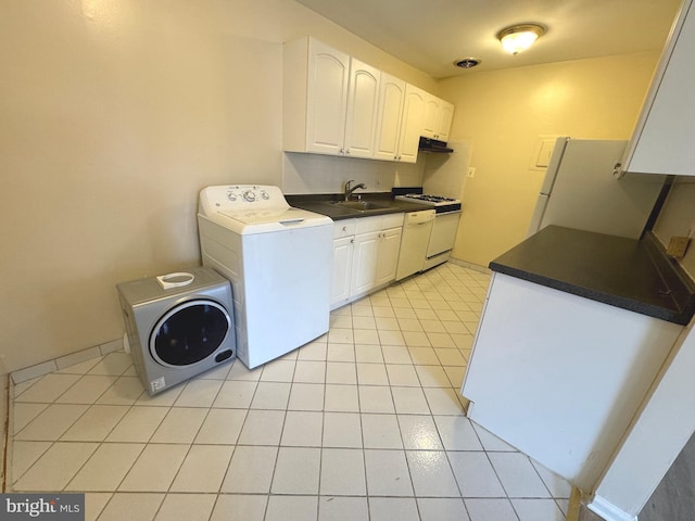 clothes washing area featuring washer / dryer, light tile patterned floors, cabinet space, and a sink