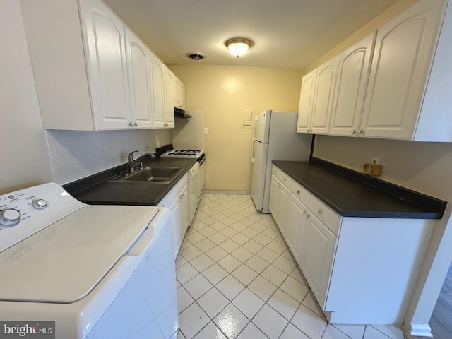 kitchen with backsplash, washer / dryer, white cabinets, white appliances, and a sink