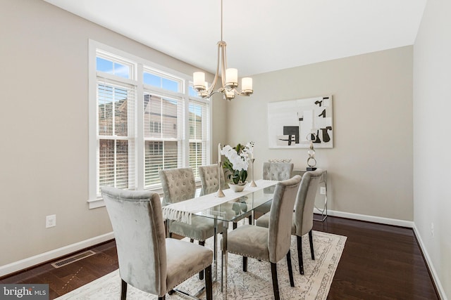 dining area featuring dark wood finished floors, baseboards, visible vents, and a chandelier