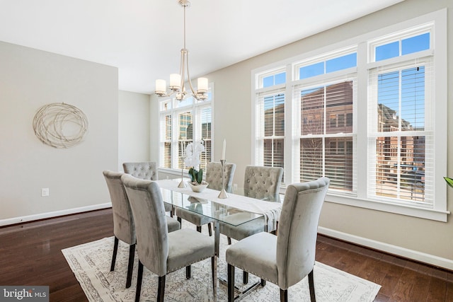 dining area featuring baseboards, an inviting chandelier, and wood finished floors