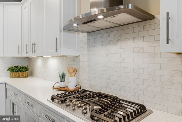 kitchen featuring white cabinetry, extractor fan, stainless steel gas stovetop, and light countertops