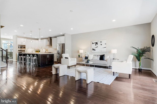 living room with dark wood-style floors, recessed lighting, and baseboards