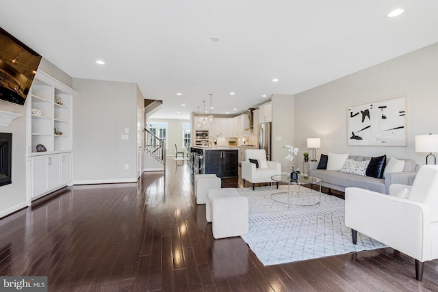 living area featuring dark wood finished floors, recessed lighting, and stairs