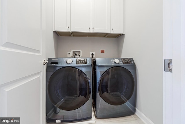 laundry room featuring washer and dryer, cabinet space, and baseboards