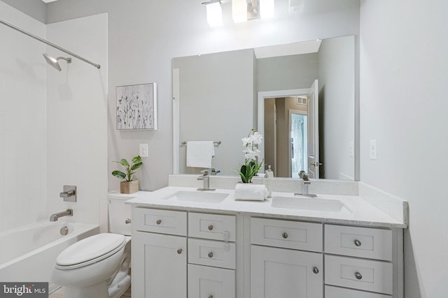 bathroom with double vanity, toilet, shower / tub combination, and a sink