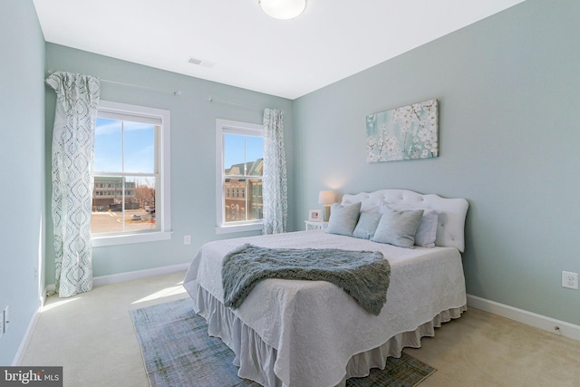 carpeted bedroom with visible vents and baseboards