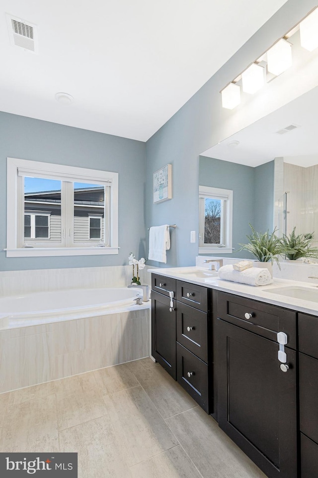 bathroom featuring a bath, visible vents, and vanity