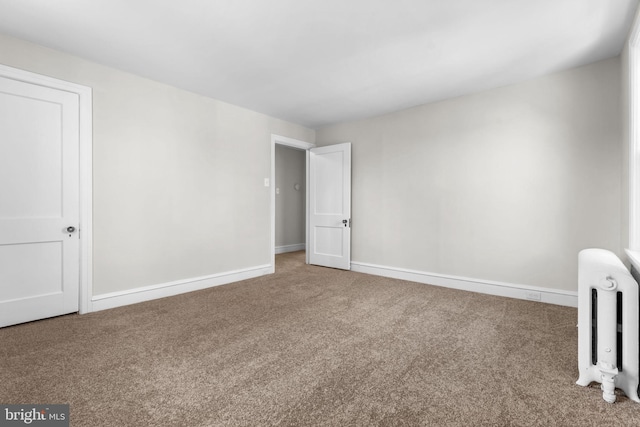 unfurnished bedroom with baseboards, radiator, and carpet flooring