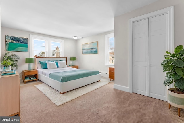 bedroom featuring carpet flooring, baseboards, a closet, and a baseboard radiator