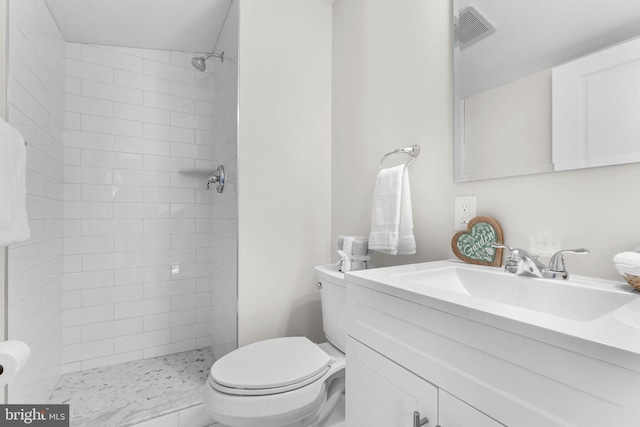 full bath featuring vanity, toilet, visible vents, and tiled shower