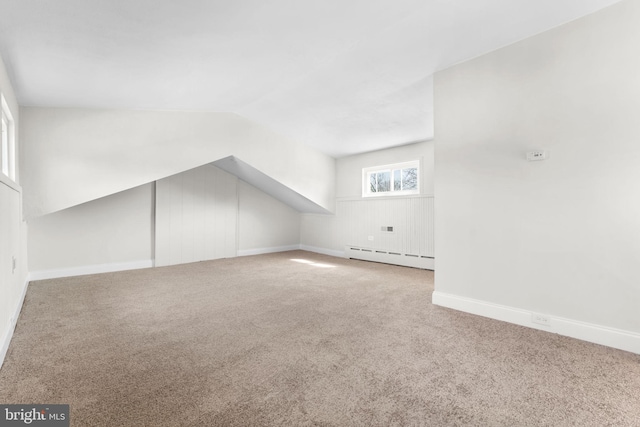 additional living space with lofted ceiling, baseboards, a baseboard heating unit, and carpet