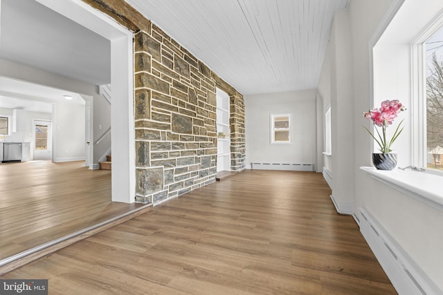 unfurnished living room featuring wood finished floors, a baseboard radiator, stairs, wood ceiling, and a baseboard heating unit