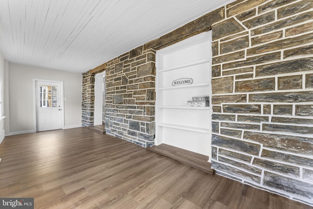 interior space with baseboards, wood finished floors, and wooden ceiling