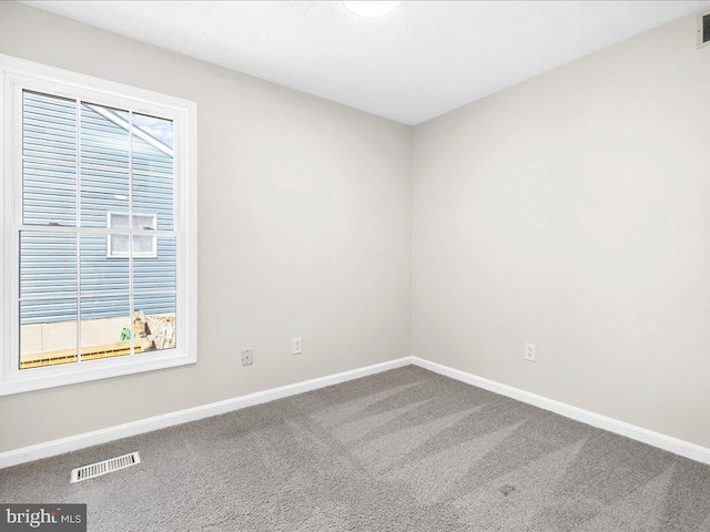 spare room with visible vents, baseboards, and carpet flooring