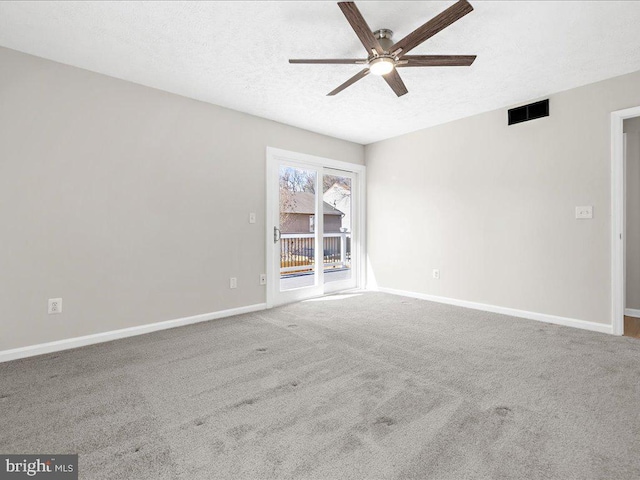 carpeted empty room with baseboards, a ceiling fan, visible vents, and a textured ceiling