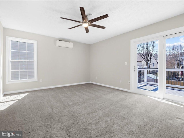 carpeted empty room featuring a wall unit AC, a ceiling fan, baseboards, and a textured ceiling