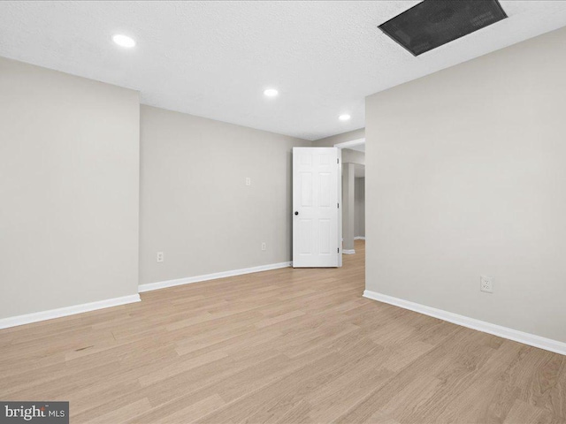 unfurnished room with recessed lighting, light wood-style floors, baseboards, and a textured ceiling