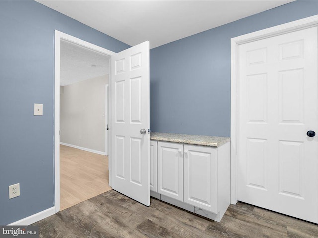 interior space with baseboards and wood finished floors