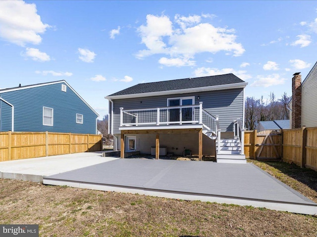 rear view of house with stairs, a patio area, a fenced backyard, and a wooden deck