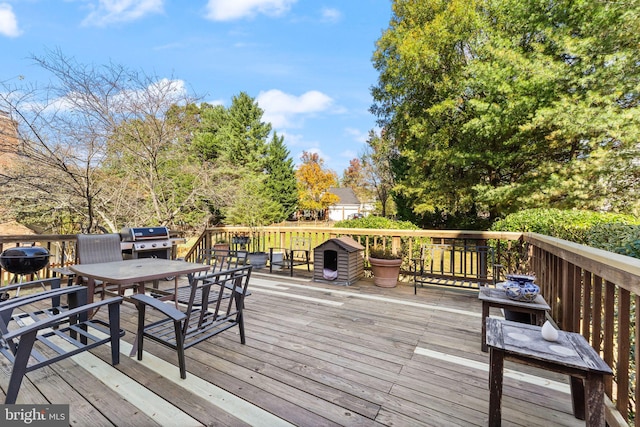 wooden deck with outdoor dining space and grilling area