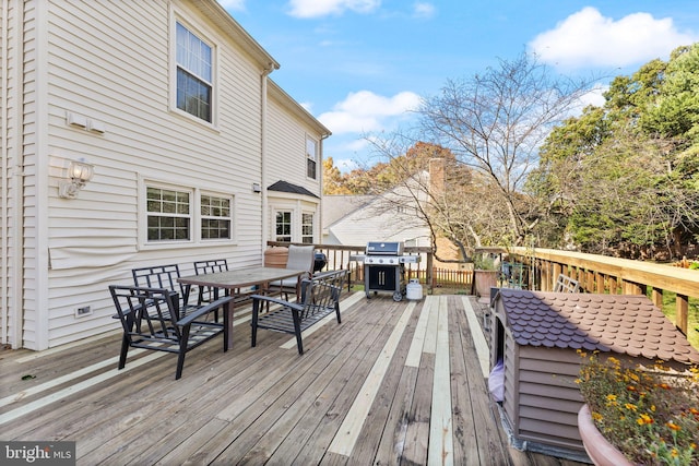 wooden terrace with outdoor dining area and grilling area