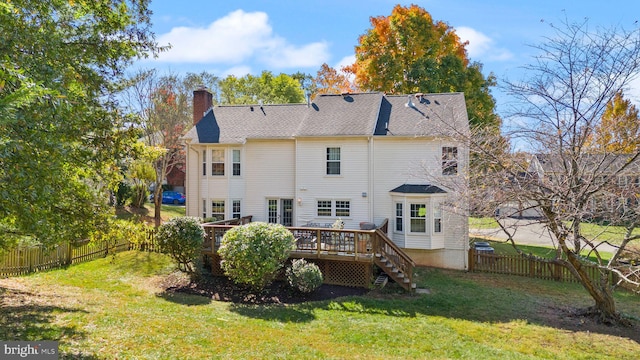 rear view of house featuring a wooden deck, a lawn, a fenced backyard, and a chimney