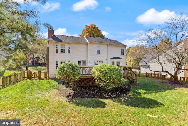 back of property with a yard, a fenced backyard, a deck, and a chimney