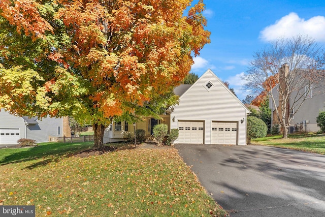 obstructed view of property with a garage, driveway, and a front yard