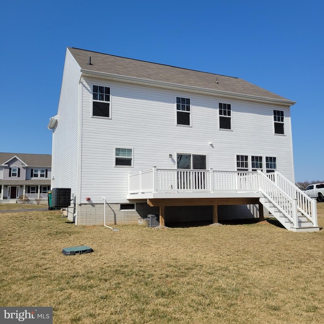 rear view of property with central air condition unit, a lawn, and a wooden deck