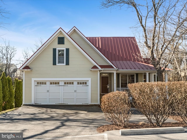 view of front facade with metal roof, aphalt driveway, and a standing seam roof