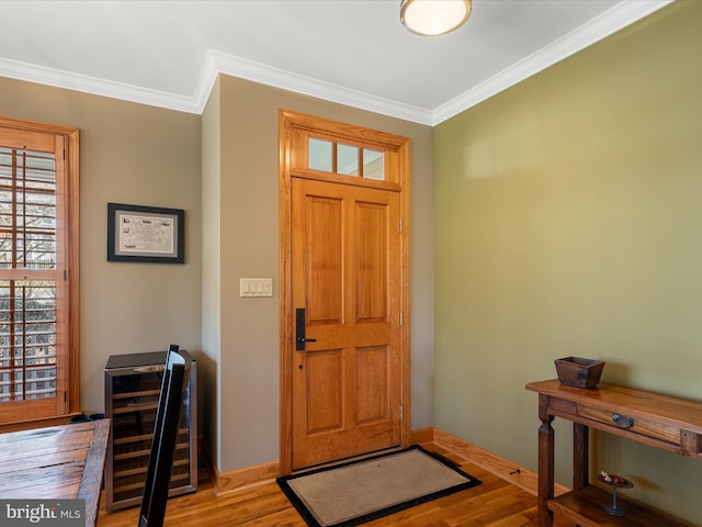 entryway featuring beverage cooler, crown molding, and wood finished floors