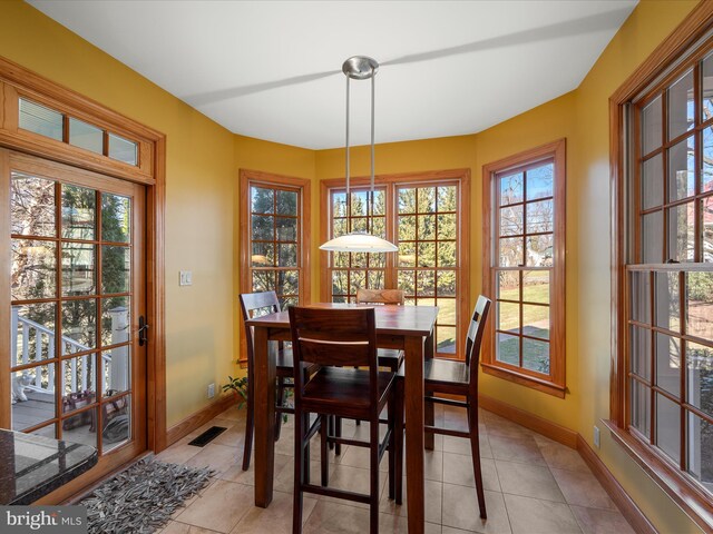 dining area featuring light tile patterned flooring, visible vents, and baseboards