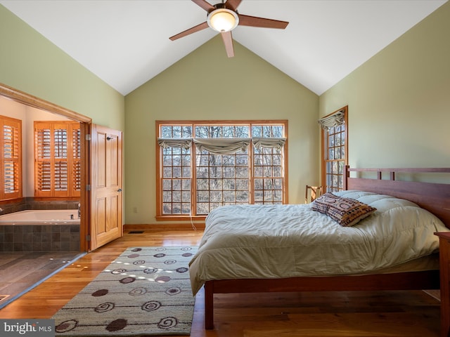 bedroom with wood finished floors and high vaulted ceiling