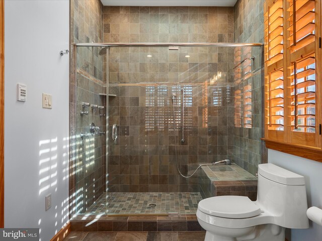 full bathroom featuring a stall shower and toilet