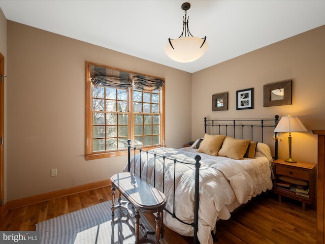 bedroom with wood finished floors and baseboards