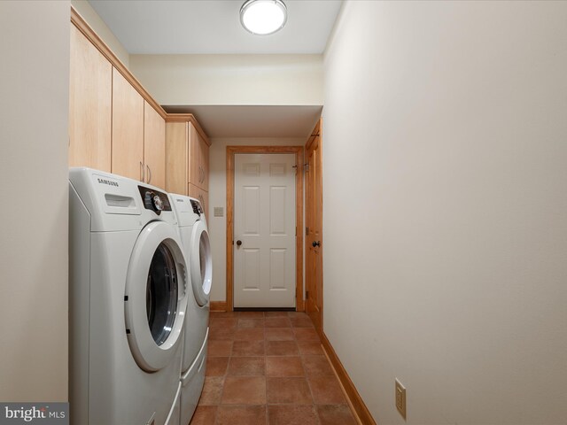 clothes washing area with cabinet space, washing machine and dryer, and baseboards