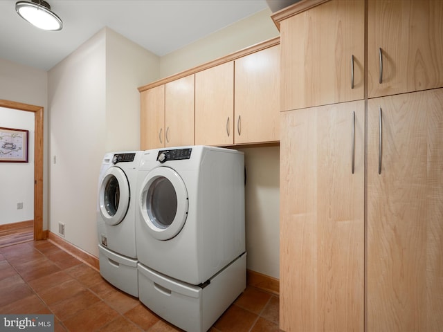 washroom with tile patterned flooring, cabinet space, baseboards, and washer and clothes dryer