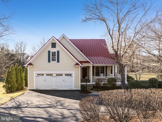 view of front of house featuring a porch, metal roof, a garage, driveway, and a standing seam roof