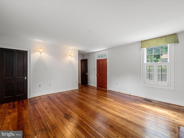 interior space with visible vents, baseboards, and hardwood / wood-style floors