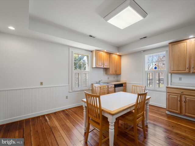 dining room with plenty of natural light, wainscoting, and hardwood / wood-style flooring