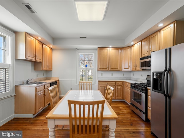 kitchen with wood-type flooring, visible vents, appliances with stainless steel finishes, and a sink